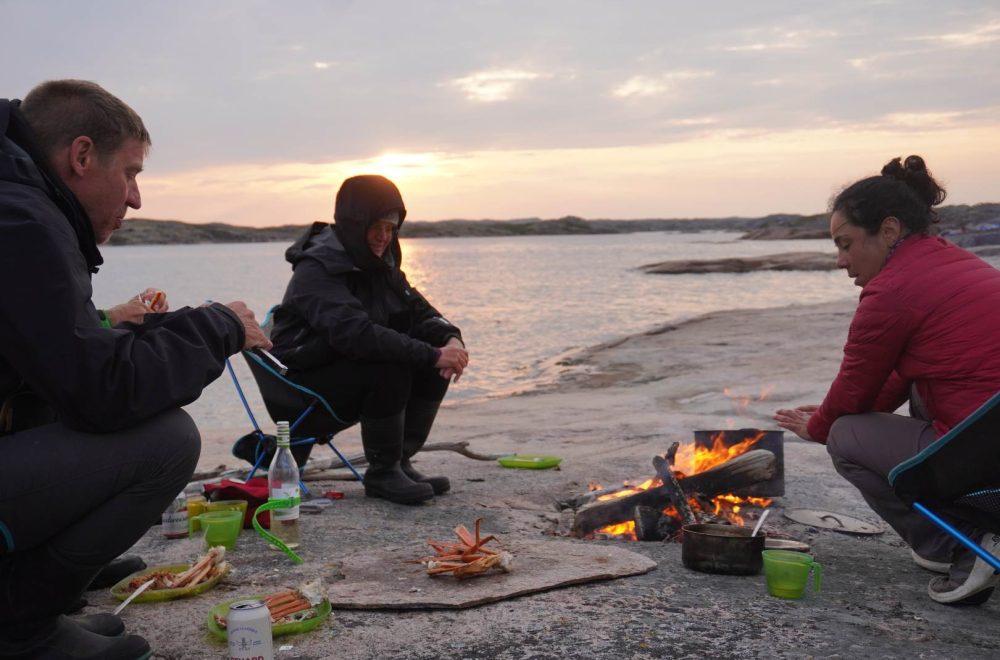 Campeurs dégustant un souper de crabes sur le feu en plein air durant une expédition de kayak